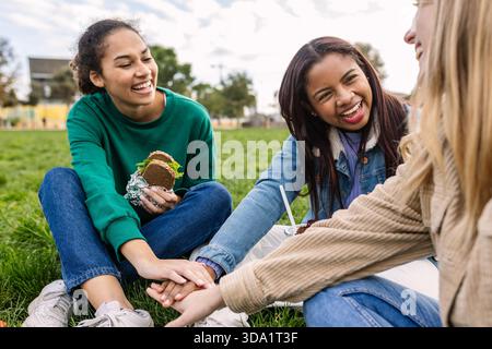 Diverse female college friends stacking hands together at university campus Stock Photo