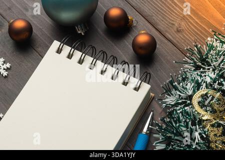 Christmas decorations and blank notebook on wooden table for holiday planning Stock Photo