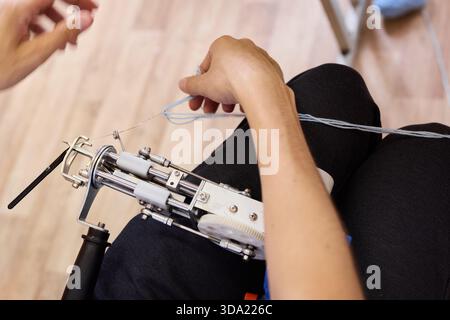 Hands using a sewing machine to stitch fabric together Stock Photo