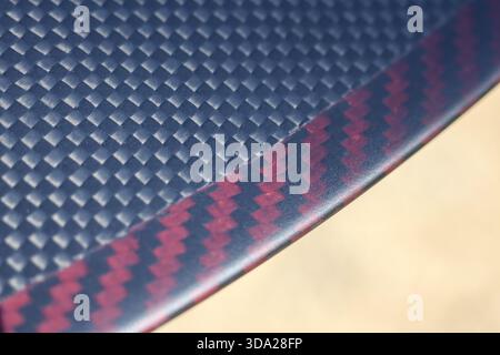 Red and black carbon fiber texture background showing modern sleek pattern. This high performance composite material represents advanced technology an Stock Photo