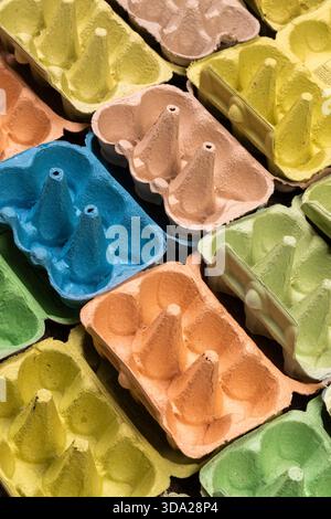 Open empty egg box cartons in different colours, viewed at an angle  in a grid pattern Stock Photo