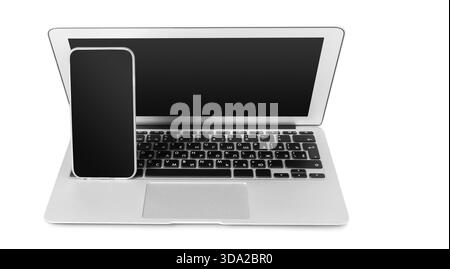 Technology setup featuring a laptop and smartphone on a white background Stock Photo