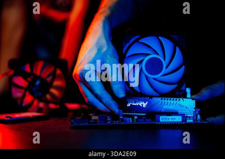 The technician is installing DDR5 RAM onto the motherboard. Stock Photo