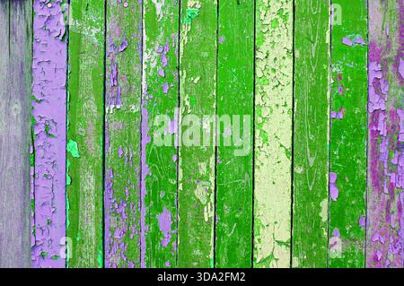 Peeling paint texture on the wooden surface. Textured wooden background with weathered wooden painted multicolor textured surface covered with peeling Stock Photo