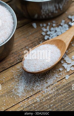 Pink Himalayan Salt in Wooden Spoon on Rustic Wooden Surface Stock Photo