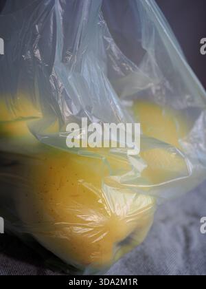 Close-Up Of Apples Wrapped In Thin Plastic Bag - Disposable Produce Packaging And Environmental Waste Problem Stock Photo