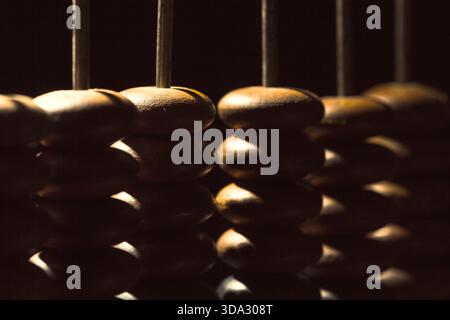 Wooden beads lined up on a traditional counting tool in dim lighting Stock Photo