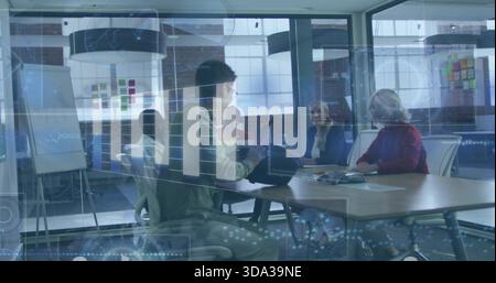 Discussing plans team sitting at glass-walled table in business attire and red sweater with laptop Stock Photo
