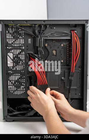 Computer Assembly Connecting Power Supply Cables inside PC Case for Optimal Performance Stock Photo