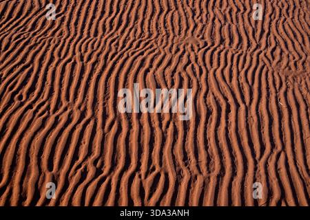 Ripples in the red sand made from the low tide rushing out on a secluded beach on Prince Edward Island in maritime Canada. Stock Photo
