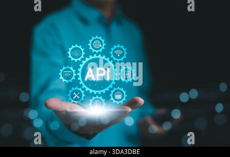 API, Application Programming Interface Concept. A person presents a glowing API (Application Programming Interface) concept surrounded by digital icon Stock Photo