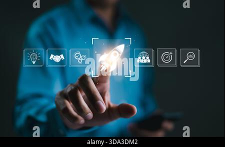 Business Growth and Startup Success Concept. A hand touching rocket icon on digital interface, symbolizing business growth, startup success, innovatio Stock Photo