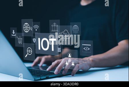 IoT Concept. Internet of Things. A person working on laptop with digital icons representing the Internet of Things (IOT), showcasing modern technology Stock Photo