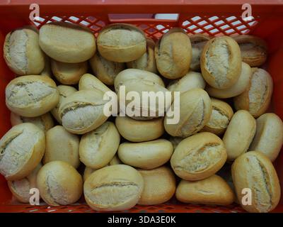 Fresh bread rolls, delivered in a red box, ready to be topped with sausage and cheese for a buffet. Stock Photo