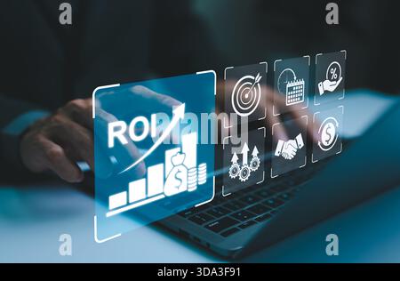 Analyzing ROI and Business Strategy Concepts. Businessman working on a laptop with various digital icons representing ROI, financial strategies, retur Stock Photo
