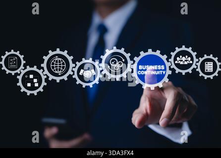 Business continuity concept. Businessman interact with gear featuring business continuity icons. strategies for maintaining operations during disrupti Stock Photo