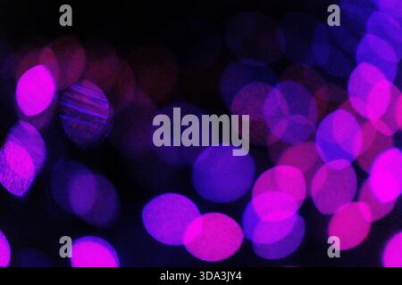 Abstract image of colourful bokeh lights with soft-focus glowing circles, creating a vibrant and atmospheric background. Stock Photo