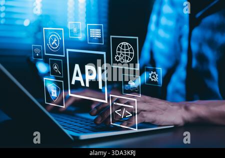 API Application Programming Interface Concept. A programmer types on a laptop, interacting with digital icons representing API development, security, Stock Photo