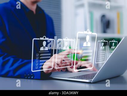 Recruitment and candidate selection concept. Businessman interacts with digital interface with multiple candidate profiles on laptop. Stock Photo