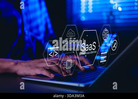 SaaS Software as a Service Concept. Man using laptop with futuristic interface SaaS (Software as a Service) icons, cloud computing, solutions, Stock Photo