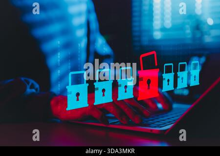 Cybersecurity and Data Breach Risk Concept. A person using laptop with digital padlock icons, red open lock symbolizing data breach, Stock Photo