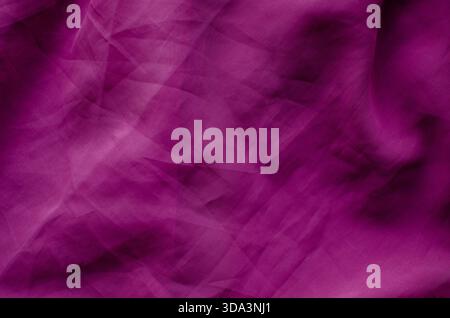 A full-frame abstract background featuring wrinkled magenta fabric with a visible woven texture. The surface is characterized by soft folds, crumpled Stock Photo