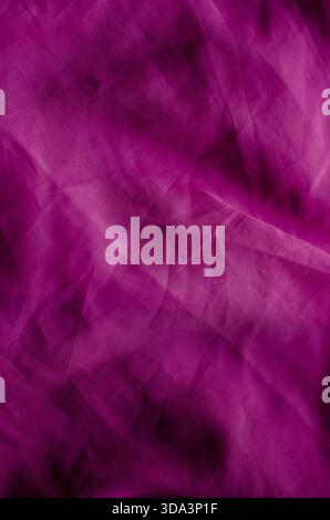 A full-frame abstract background featuring wrinkled magenta fabric with a visible woven texture. The surface is characterized by soft folds, crumpled Stock Photo
