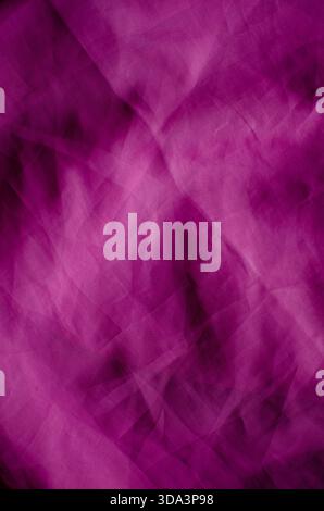 A full-frame abstract background featuring wrinkled magenta fabric with a visible woven texture. The surface is characterized by soft folds, crumpled Stock Photo