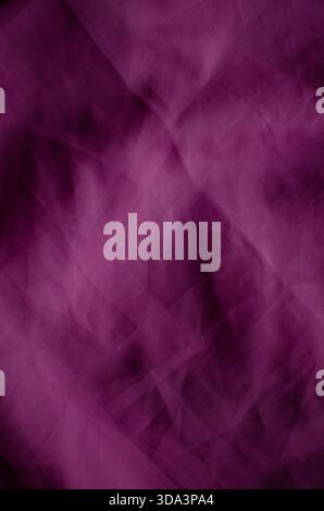 A full-frame abstract background featuring wrinkled magenta fabric with a visible woven texture. The surface is characterized by soft folds, crumpled Stock Photo