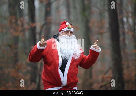 jolly santa claus in a forest pointing upwards Stock Photo