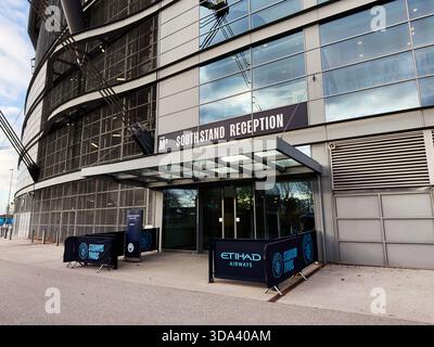 Manchester, UK - November 16, 2025: Exterior view of the City of Manchester Stadium south stand reception with Etihad tours branding. Stock Photo