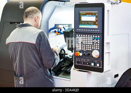 Worker at a lathe milling machine Stock Photo