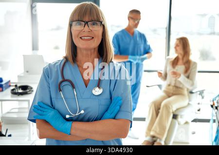 A warm and inviting healthcare environment that features a team of dedicated medical staff providing care and support to a patient in a doctors office Stock Photo