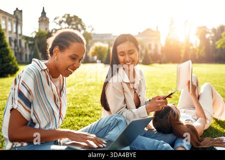 The vibrant academic community reflects a wide variety of student experiences, with students happily studying and socializing on a sunny campus. It em Stock Photo