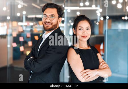 People working in a coworking space. Two business employees in formal suits standing with their arms crossed in a modern office. Stock Photo