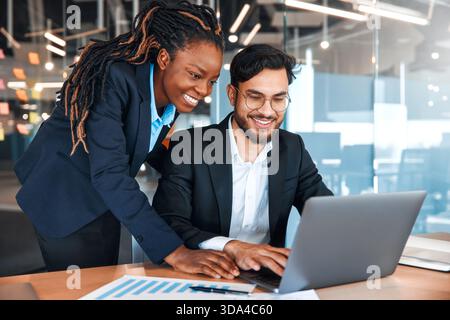 Successful young people working in a coworking space. African American Woman With Her Team Working With Laptop Discussing Strategy And Business Plan I Stock Photo