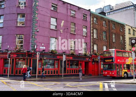 Street scene in Dublin, Ireland, featuring a colorful pub and a red double-decker bus. Dublin, Ireland, 2025-08-08 Stock Photo