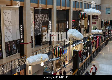 People browse shops and enjoy the Christmas decorations in the Grand Arcade shopping centre in Cambridge, England Stock Photo