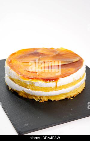 Sweet caramel sponge cake on a black slate, offering a delicious dessert pastry Stock Photo