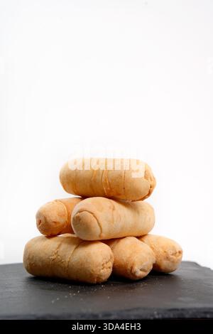 Golden brown fried venezuelan tequeños, cheese sticks, stacking on a dark slate plate Stock Photo