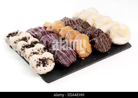 Delicious glazed mini donuts arranged on a dark serving platter Stock Photo