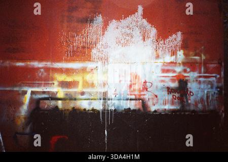 Analog flash shot of a red workshop wall with spray paint marks, creating an abstract textured composition, captured on Olympus film camera. Stock Photo