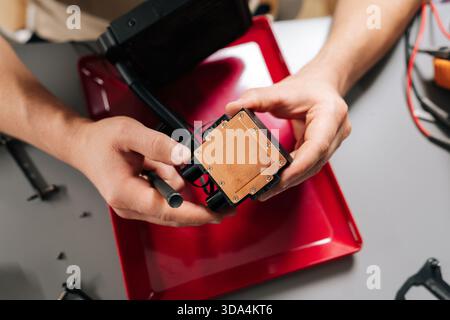 Close-up of technician hands installing liquid cooling system CPU block on computer hardware, performing maintenance, assembly, upgrade of high Stock Photo