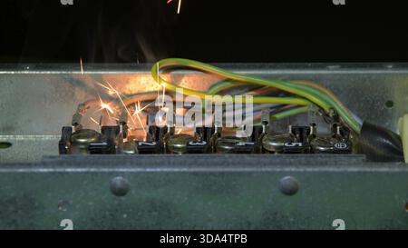An open electrical panel demonstrates a short circuit with intense sparks and smoke Stock Photo