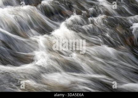 Fast flowing river water with long exposure movement Stock Photo