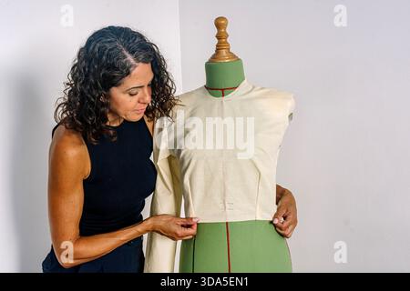 Woman designer adjusting garment pattern on a mannequin Stock Photo