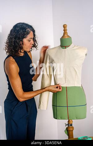 Woman fashion designer working on pattern on mannequin Stock Photo
