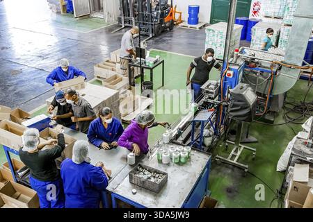 Johannesburg, South Africa - October 19, 2012: Diverse people working on an assembly line in a glue factory Stock Photo