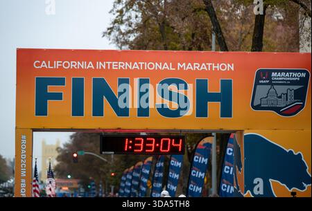 A close-up view of finish line gate with clock at the California International Marathon (CIM) on Capitol Mall with Tower Bridge visible. Stock Photo