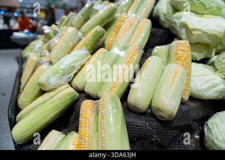 Fresh green vegetables like peas, beans, and cucumbers in a market for a healthy vegetarian diet Stock Photo